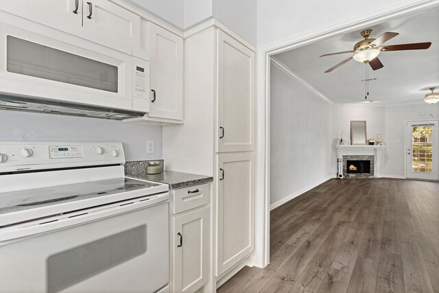 kitchen featuring white appliances, ornamental molding, a fireplace, dark hardwood / wood-style flooring, and white cabinetry