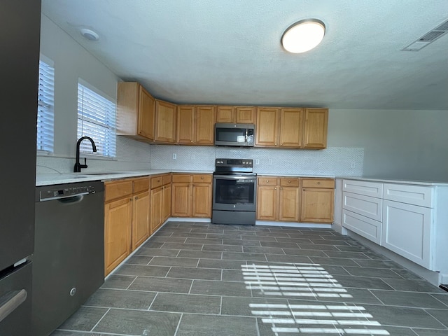 kitchen with sink, tasteful backsplash, and black appliances