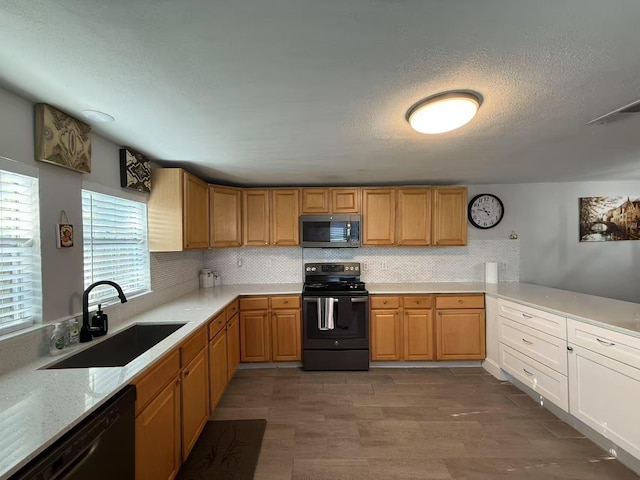2925 Janet Dr, Wylie, TX 75098 - kitchen featuring black appliances, a sink, backsplash, a textured ceiling, and wood finished floors