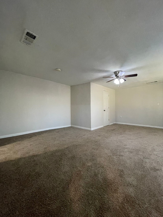 carpeted empty room with ceiling fan and a textured ceiling