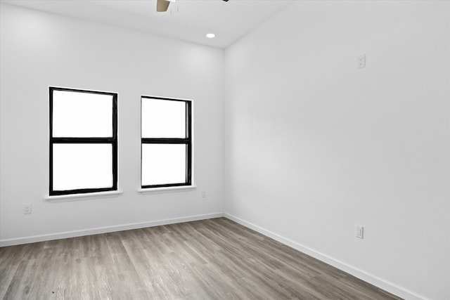 empty room with ceiling fan and light hardwood / wood-style floors