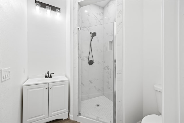 bathroom with vanity, toilet, and tiled shower