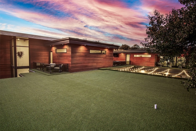 back house at dusk with a swimming pool