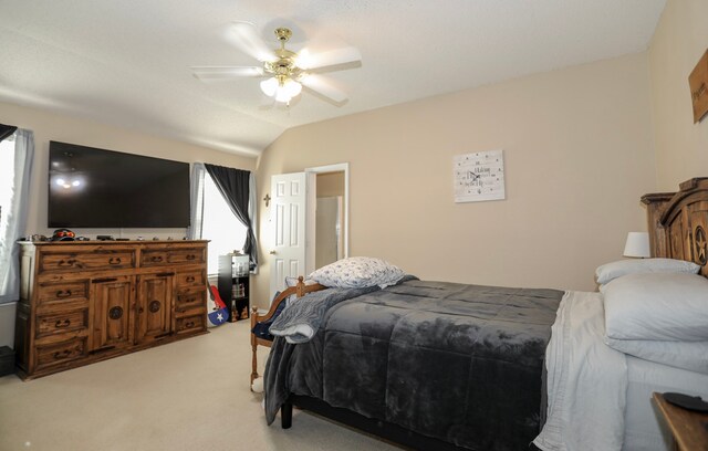 bedroom with ceiling fan, light colored carpet, and vaulted ceiling