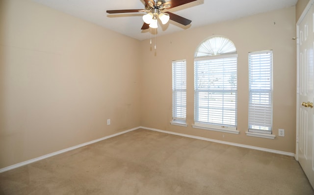 carpeted spare room featuring ceiling fan