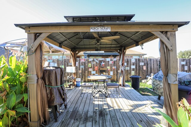 wooden terrace with a gazebo and ceiling fan