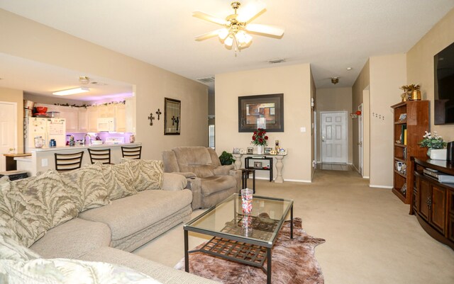 carpeted living room featuring ceiling fan