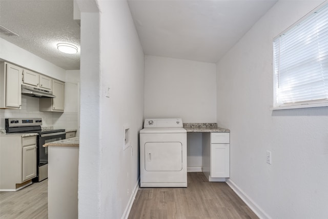 laundry room featuring washer / dryer, a textured ceiling, and light hardwood / wood-style flooring