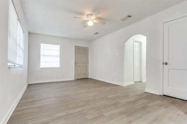 empty room featuring ceiling fan, light hardwood / wood-style floors, and a textured ceiling