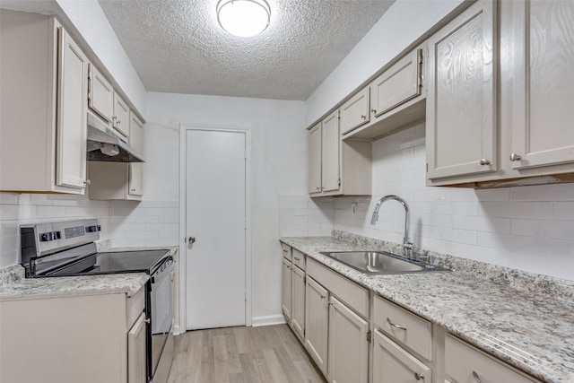 kitchen featuring stainless steel range with electric stovetop, sink, decorative backsplash, light wood-type flooring, and a textured ceiling