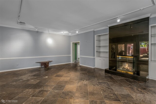 unfurnished living room with built in shelves, crown molding, and track lighting