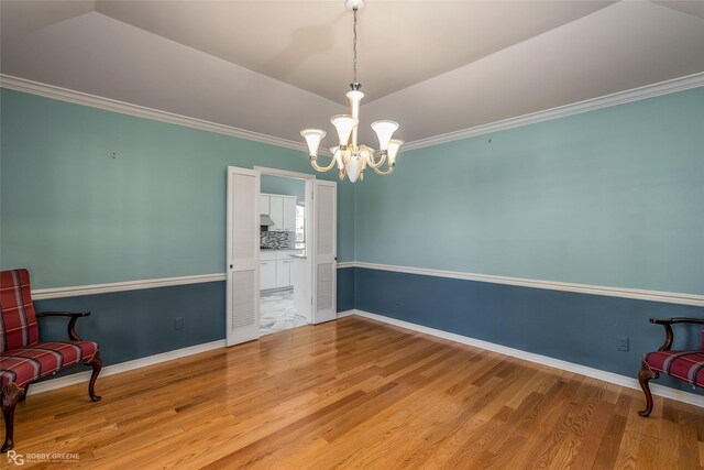 sitting room featuring vaulted ceiling, hardwood / wood-style flooring, an inviting chandelier, and crown molding