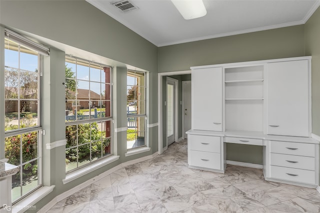 interior space with built in desk and crown molding