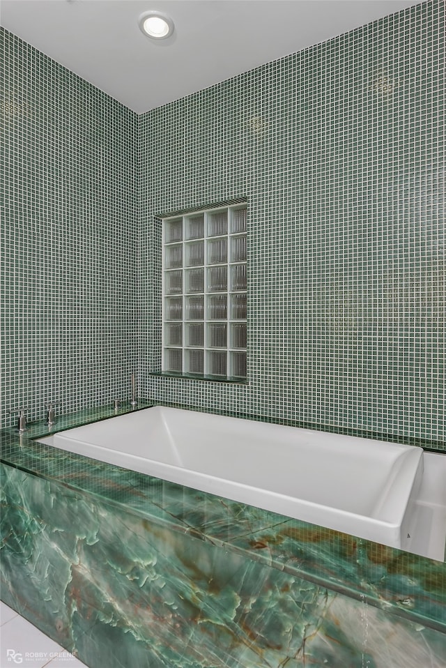 bathroom with tiled bath and tile walls