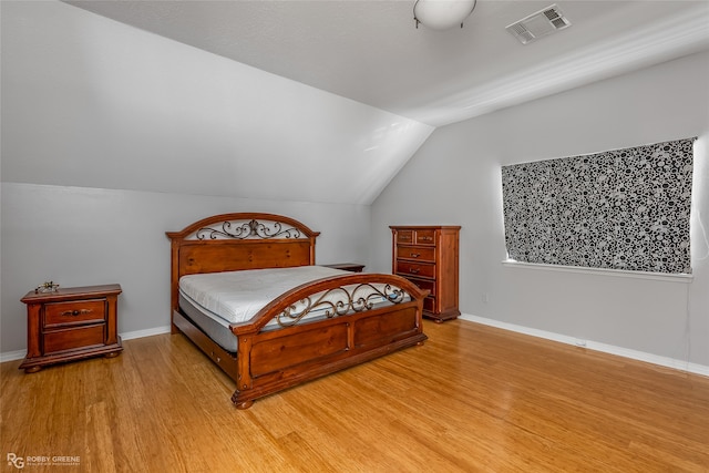 bedroom with hardwood / wood-style flooring and vaulted ceiling