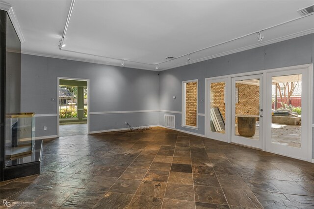 spare room with crown molding and rail lighting