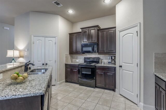 kitchen with decorative backsplash, light stone counters, sink, black appliances, and light tile patterned flooring