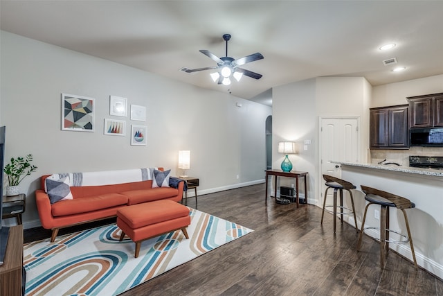 living room featuring ceiling fan and dark hardwood / wood-style flooring