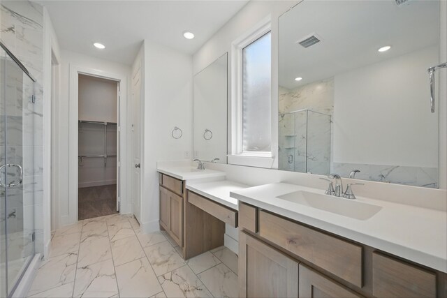 bathroom with a marble finish shower, visible vents, a spacious closet, marble finish floor, and vanity