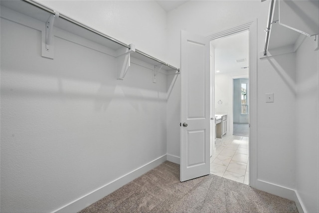 spacious closet featuring light carpet