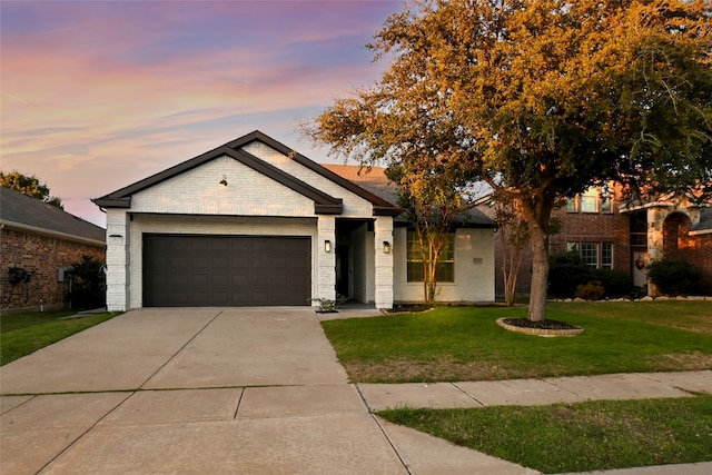 view of front facade with a garage and a lawn