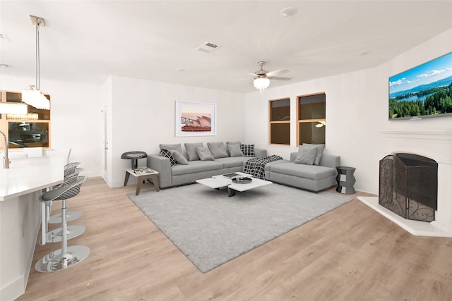 living room with ceiling fan and light hardwood / wood-style flooring