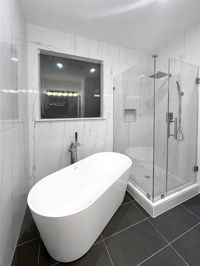 bathroom with tile patterned floors, separate shower and tub, and tile walls