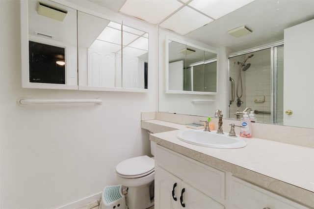 bathroom with a shower with door, vanity, and toilet