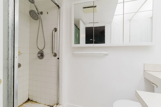 bathroom featuring a tile shower and toilet