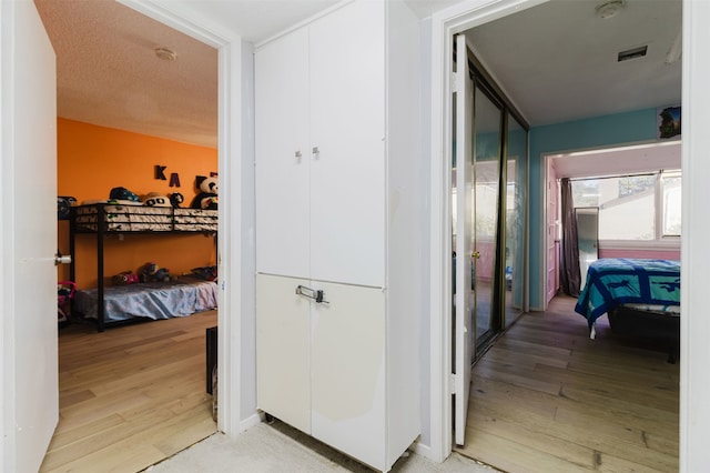 hallway featuring wood-type flooring and a textured ceiling