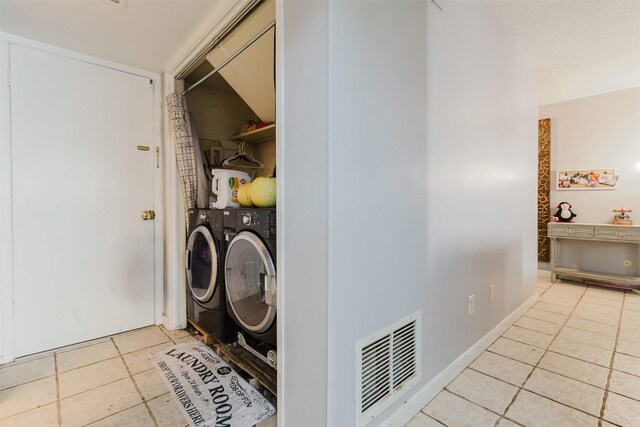 laundry room with independent washer and dryer and light tile patterned flooring