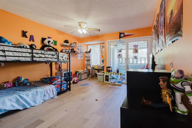 bedroom featuring wood-type flooring, a textured ceiling, and ceiling fan