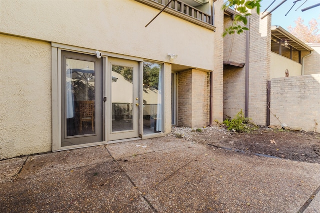 view of exterior entry with a patio