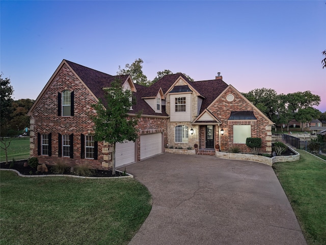 view of front of property with a yard and a garage