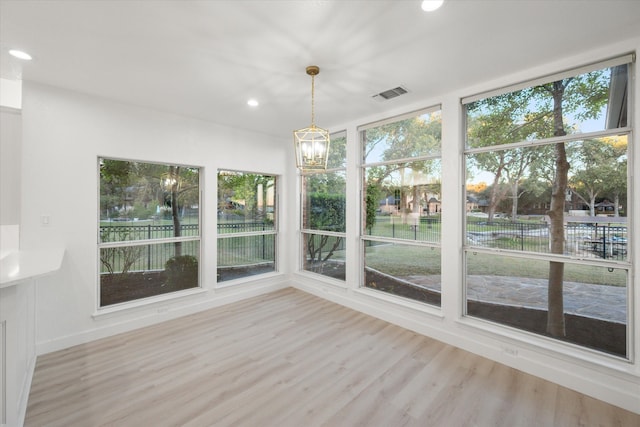 unfurnished sunroom featuring a wealth of natural light and a notable chandelier