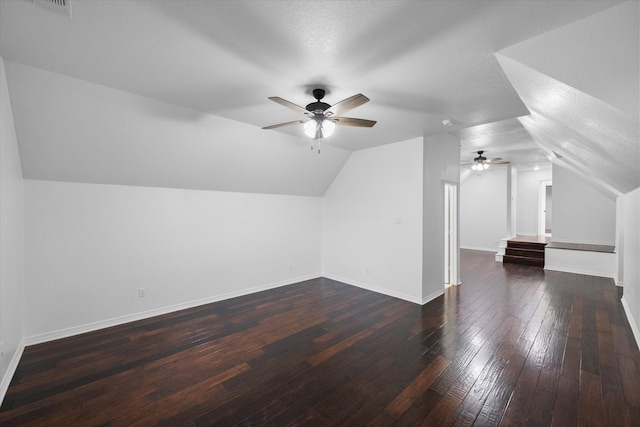 additional living space featuring a textured ceiling, ceiling fan, dark hardwood / wood-style flooring, and lofted ceiling