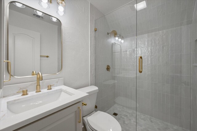 bathroom with vanity, toilet, and a shower with door