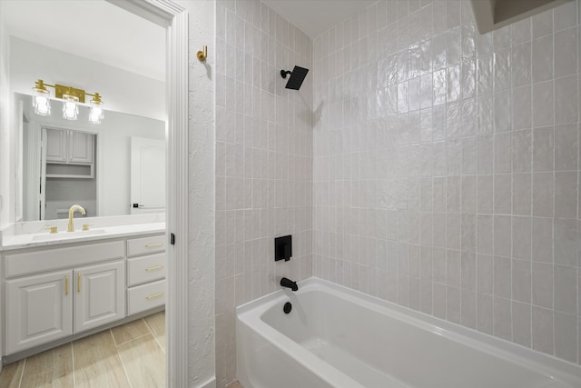 bathroom with tiled shower / bath combo and vanity