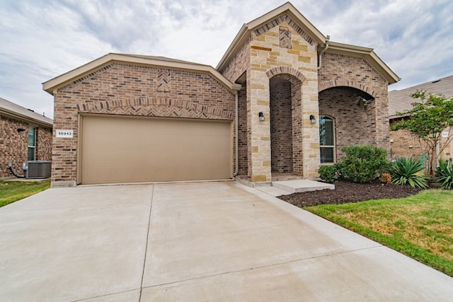 view of front facade with a garage and central AC