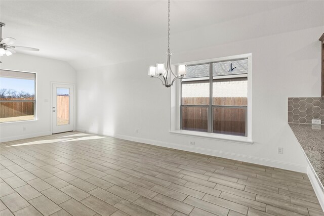 unfurnished dining area with lofted ceiling, plenty of natural light, and ceiling fan with notable chandelier