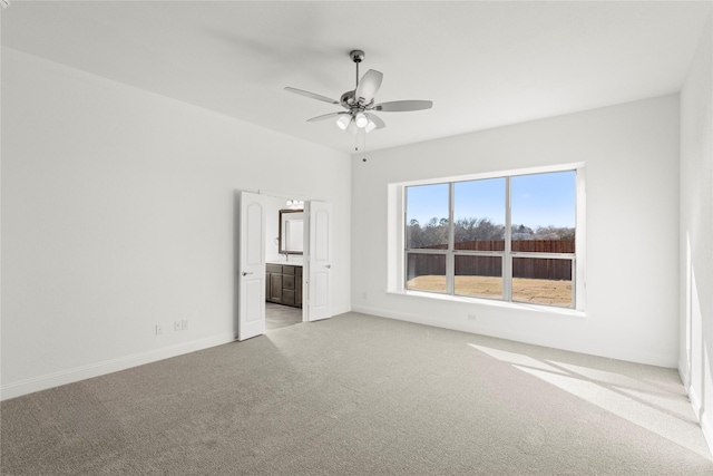 unfurnished bedroom with light carpet, connected bathroom, and ceiling fan