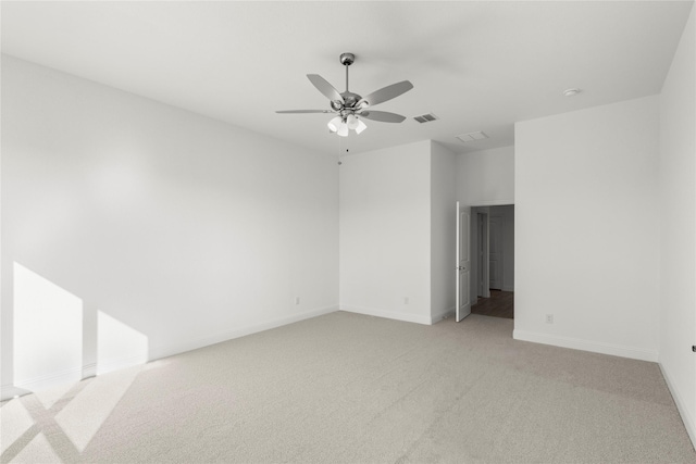 empty room with ceiling fan and light carpet