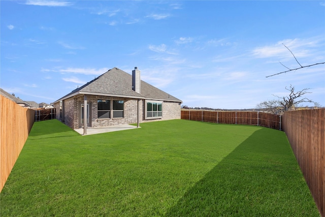 rear view of house featuring a yard and a patio