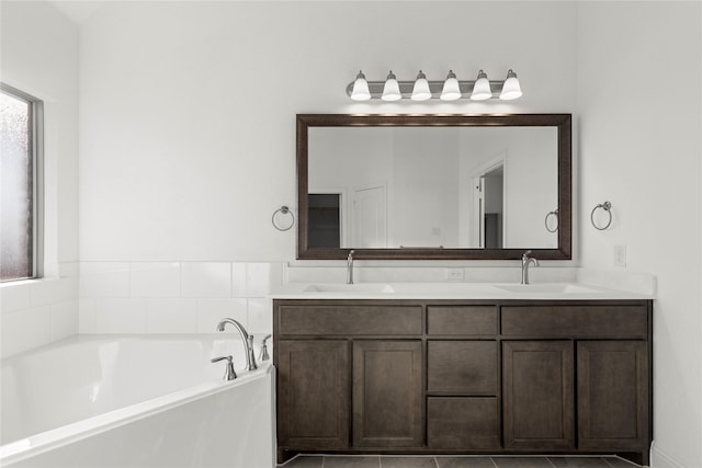 bathroom featuring tile patterned floors, vanity, and a tub to relax in