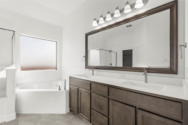 bathroom featuring tile patterned flooring, vanity, and shower with separate bathtub