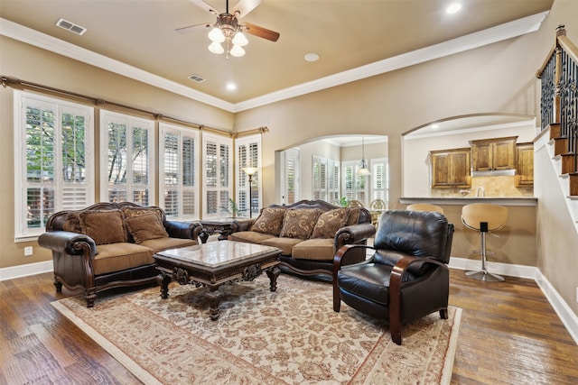 living room with ceiling fan, dark hardwood / wood-style flooring, crown molding, and a wealth of natural light