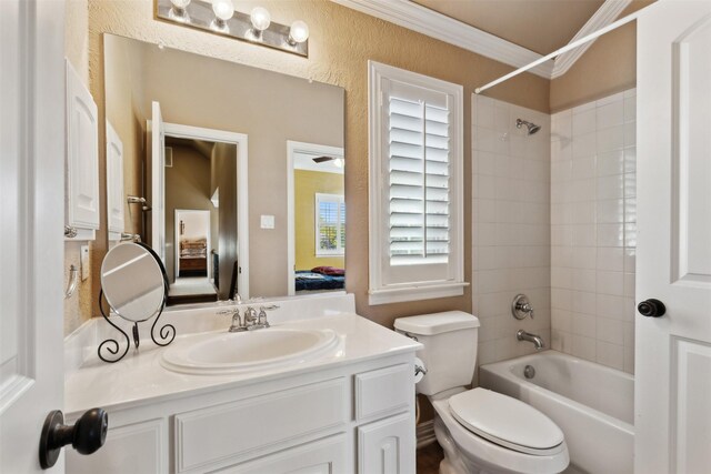 full bathroom with vanity, toilet, ornamental molding, and tiled shower / bath