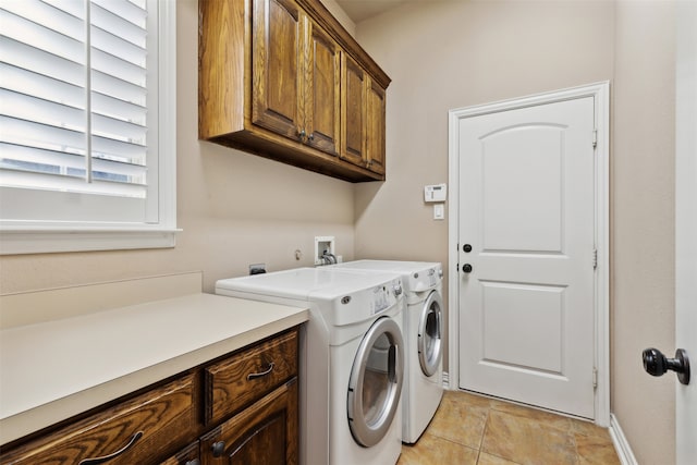 laundry room with cabinets, light tile patterned floors, and washer and clothes dryer