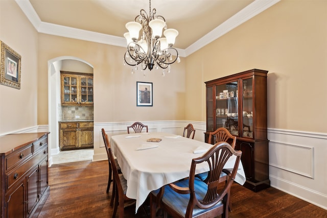 dining space featuring dark hardwood / wood-style floors, crown molding, and a notable chandelier