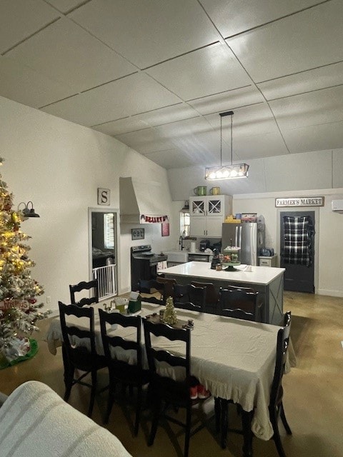 dining area featuring a paneled ceiling and concrete flooring